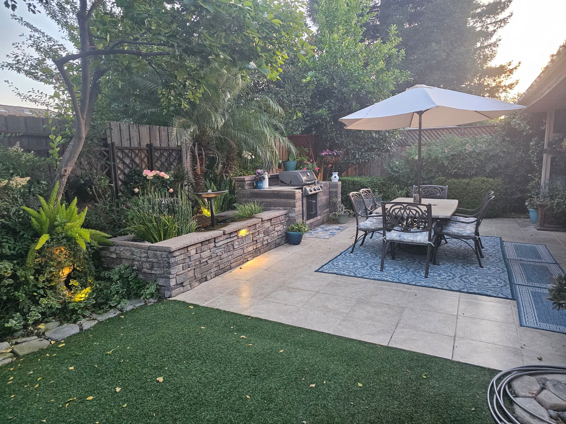 Small Backyard Packed With a Patio, BBQ Island, and Water Feature image